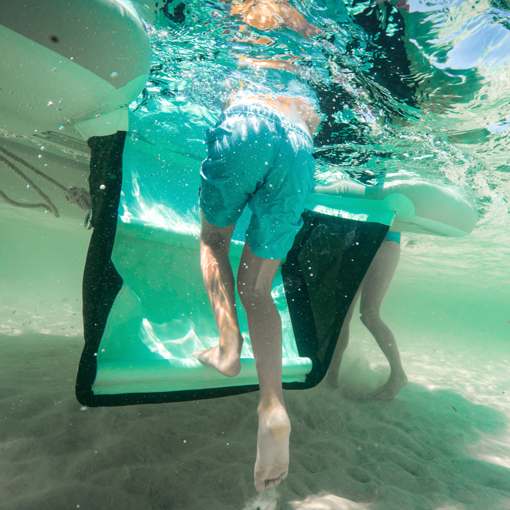 Underwater view of someone walking up the Inflatable Hangout Ladder Classic