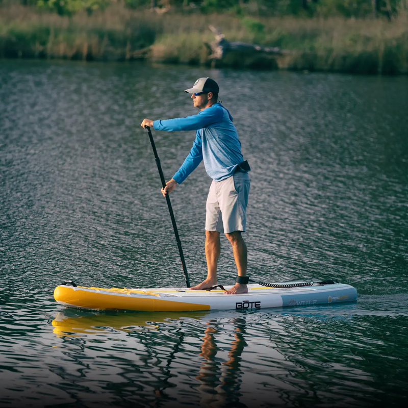 A guy paddling on a WULF Aero 10'4" Native Coral Inflatable Paddle Board