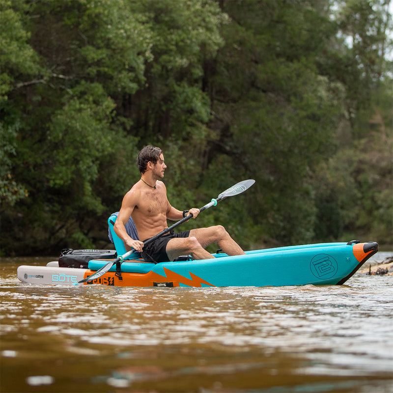 Man paddling on a blue and orange kayak on a river