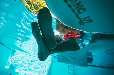 Underwater view of person sitting in the Inflatable Hangout Sling Chair.