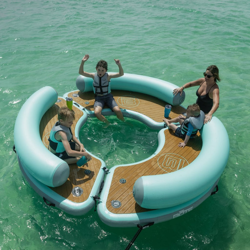 A mom and kids hanging out on the Inflatable Dock Hangout 360 Trio