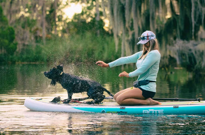 Woman and dog on a paddleboard in a natural setting