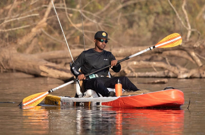 Man paddling while seated in the Rackham Aero kayak.