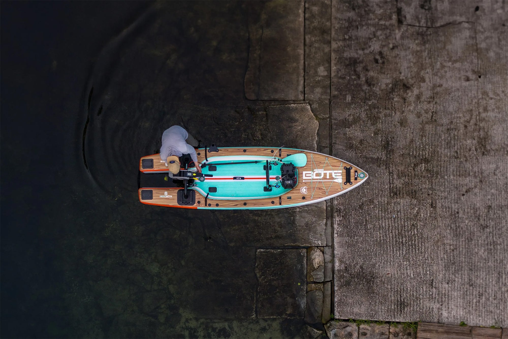 Top view of Rover Aero micro skiff beside boat ramp with man preparing to launch.