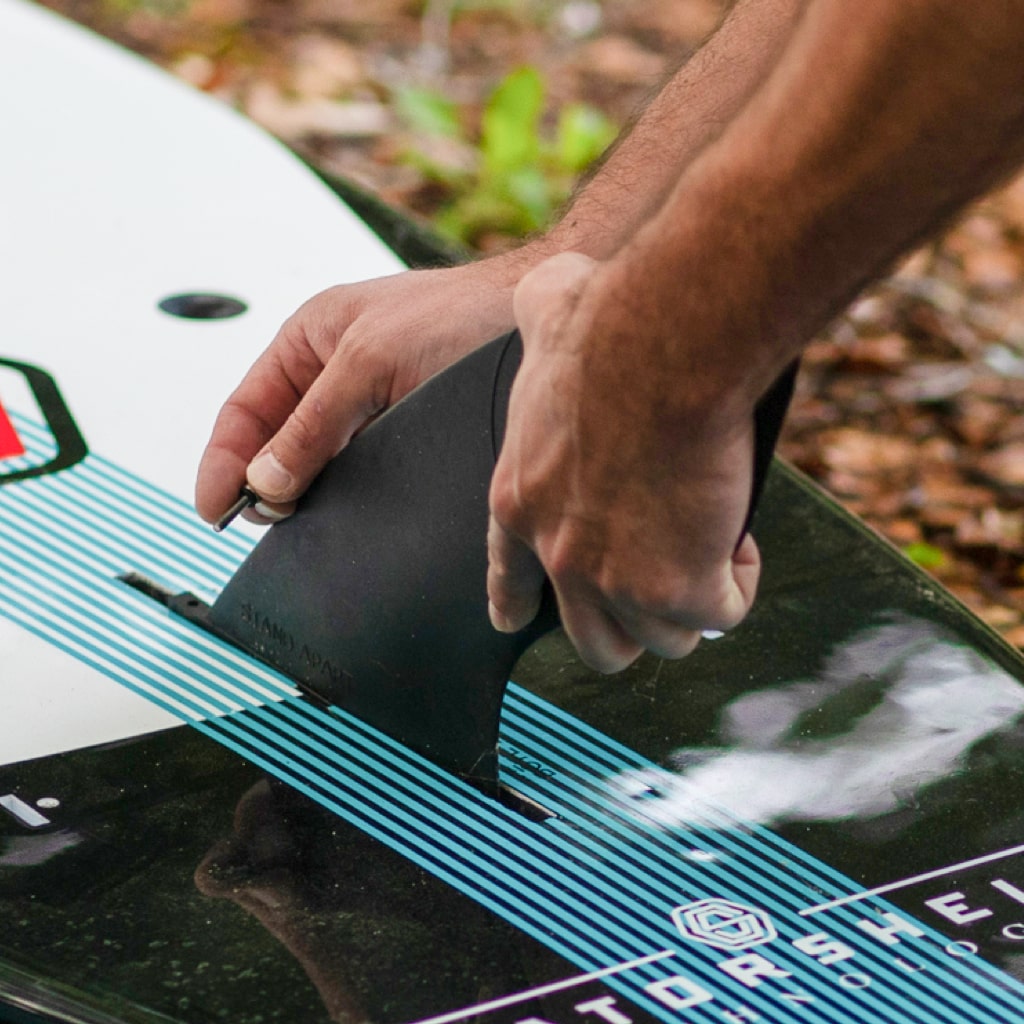Man fitting center fin screw into center fin on his Gatorshell paddle board