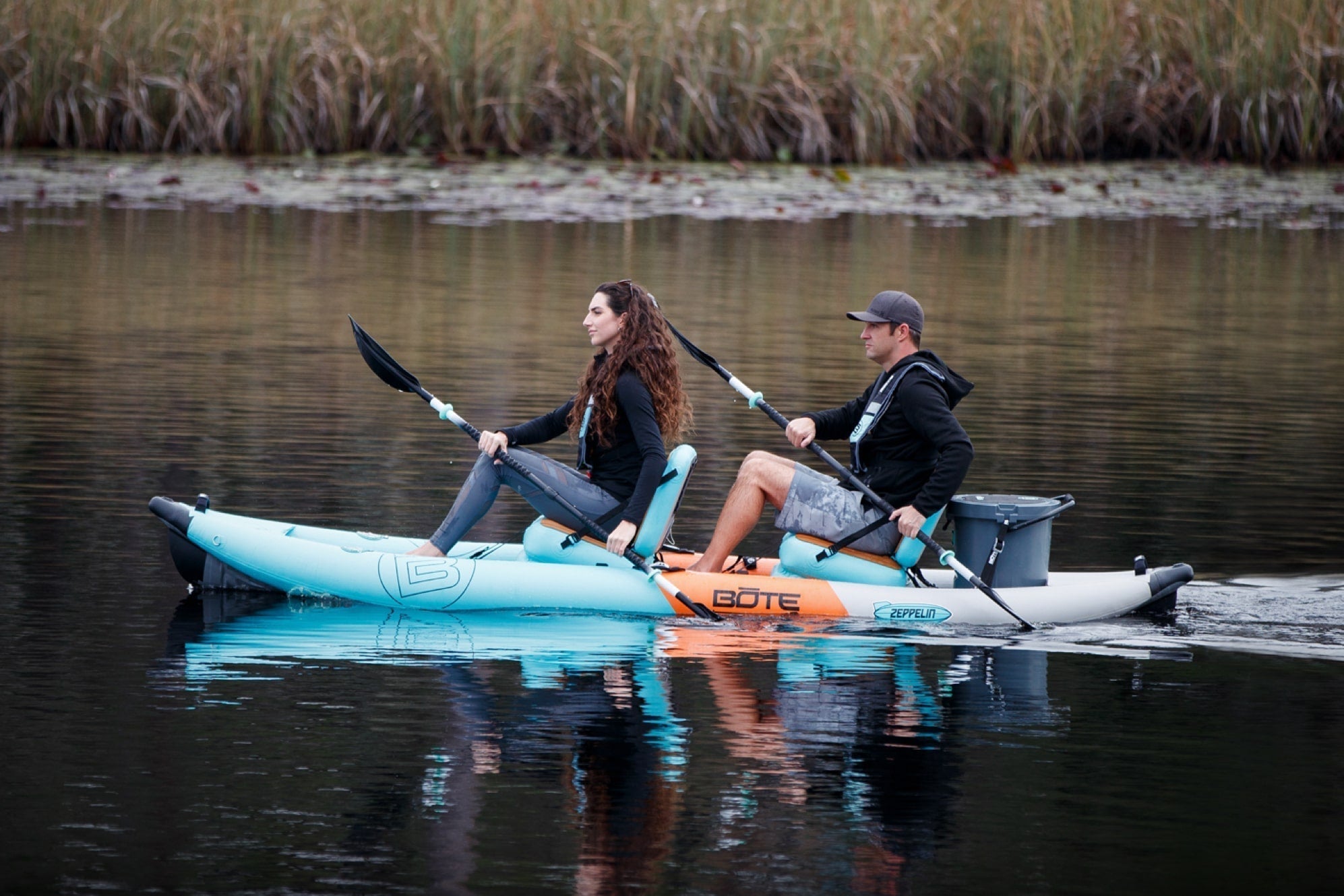 Two kayakers on the Zeppelin Aero seated, paddling on calm water