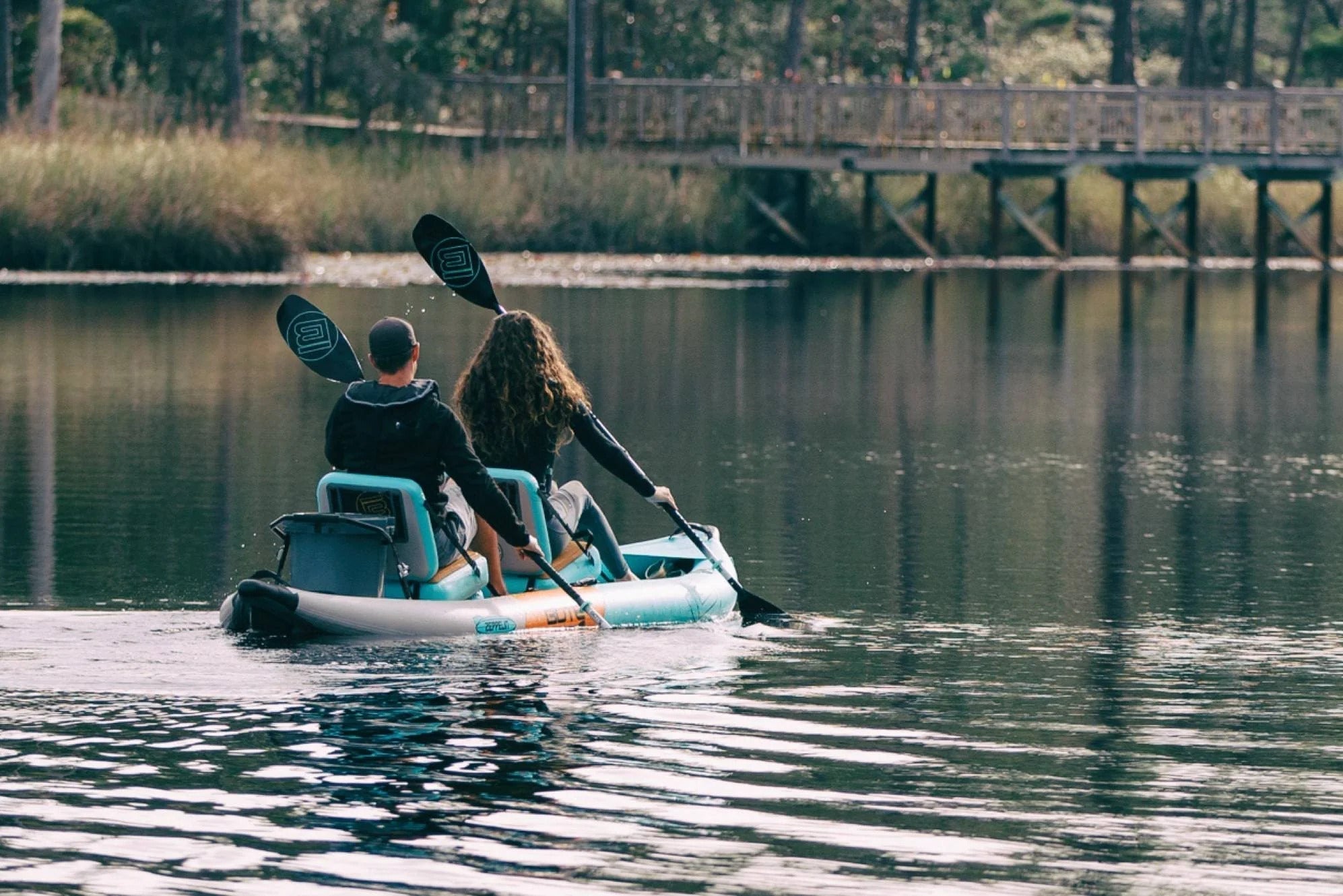 Two people on the Zeppelin tandem kayak on a calm lake.