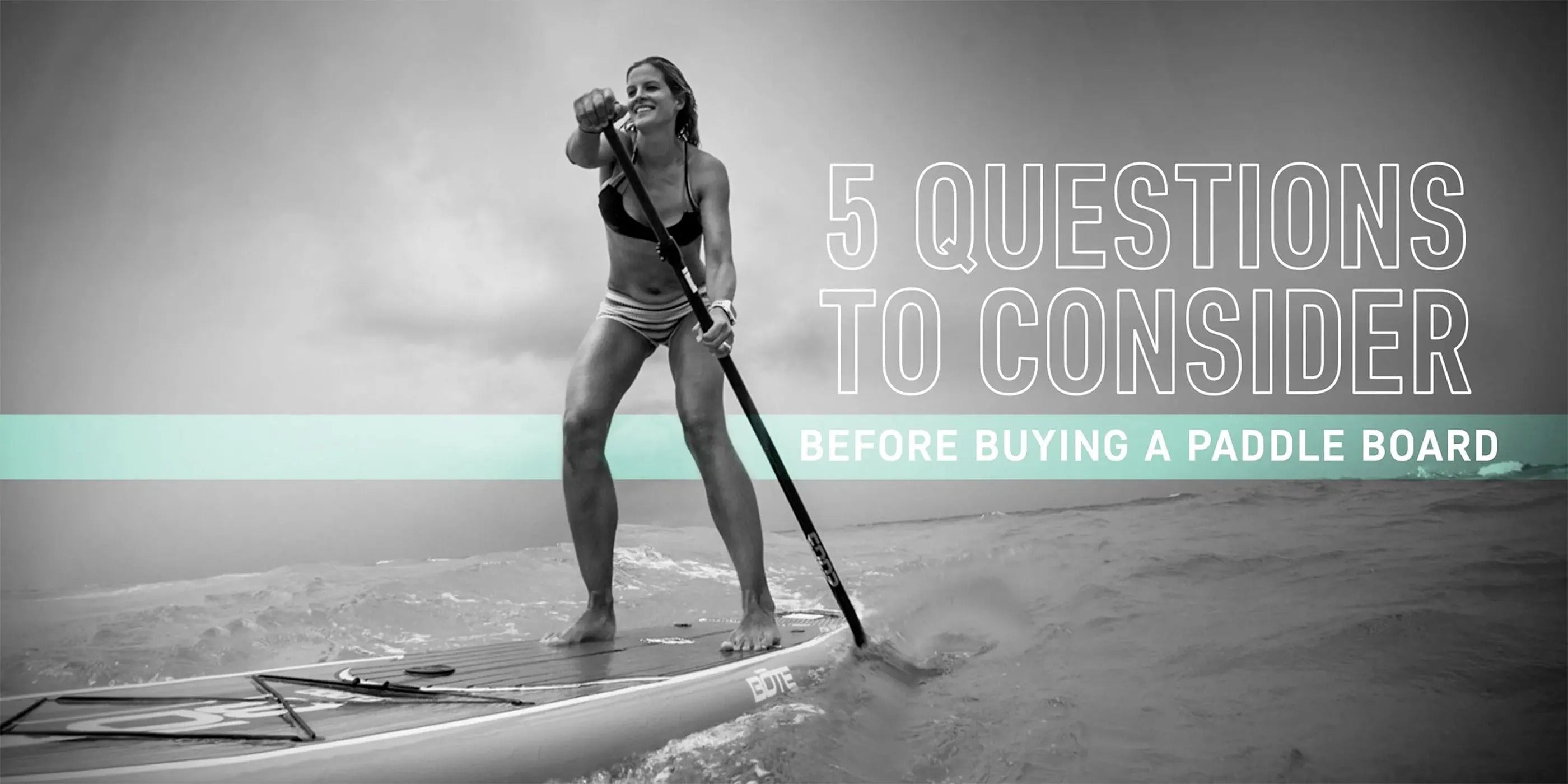Black and white photo of a woman paddling on calm water with a text overlay that says "5 Questions to consider befoore buying a paddle board"