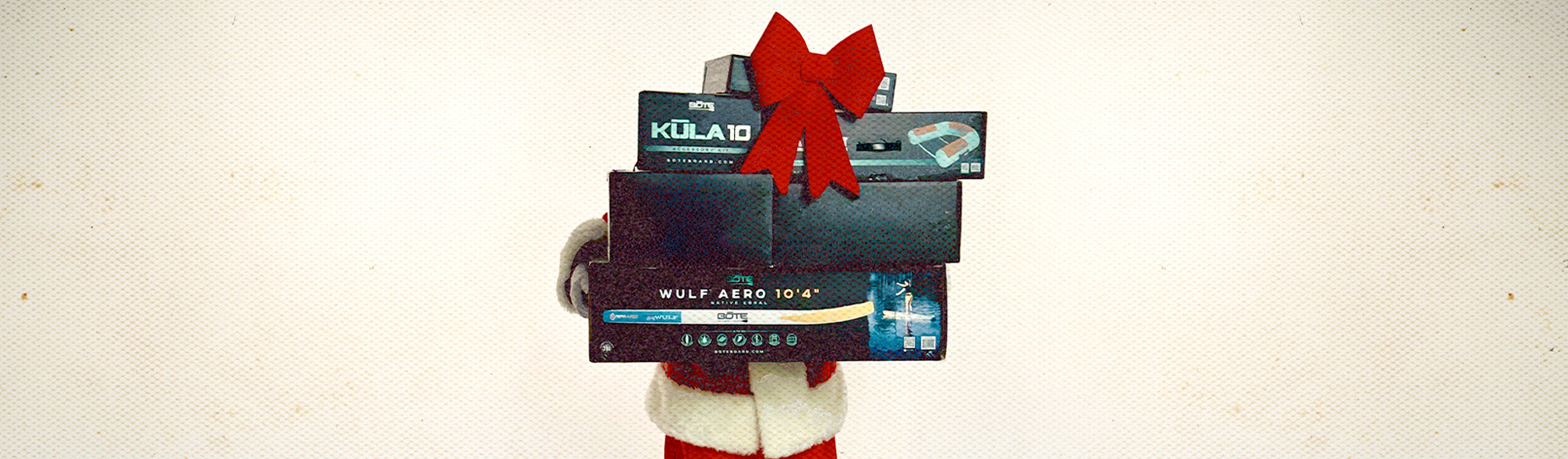 Stack of BOTE boxes tied with a red ribbon on a beige background