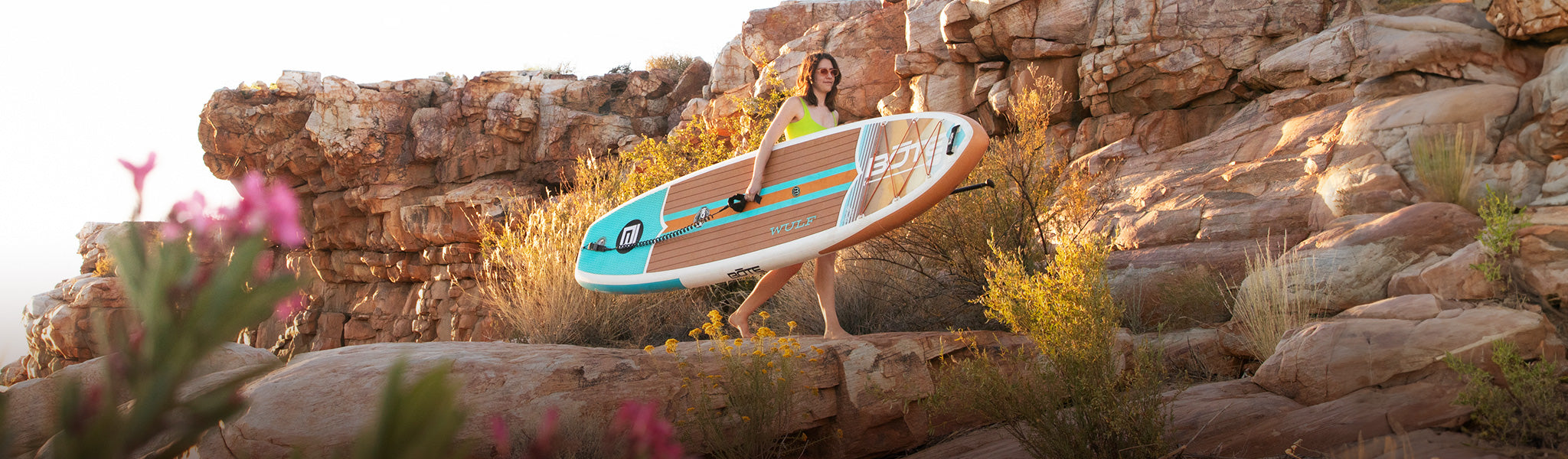 Woman carrying WULF Aero Inflatable Paddle Board
