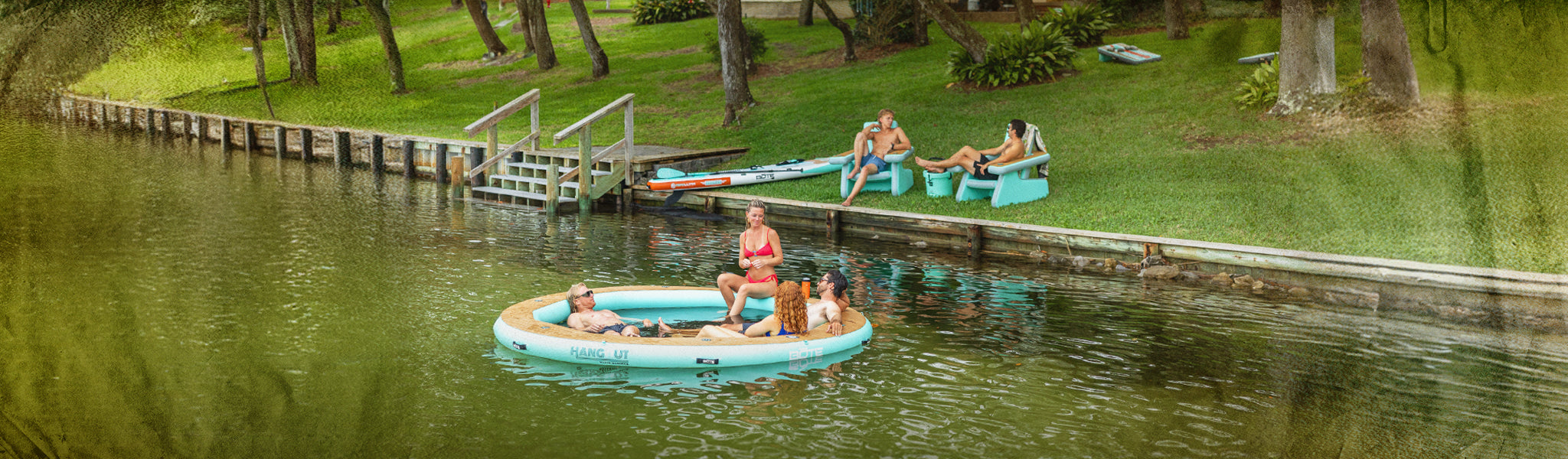 People enjoying a day on a lake with inflatable rafts and lounge chairs.