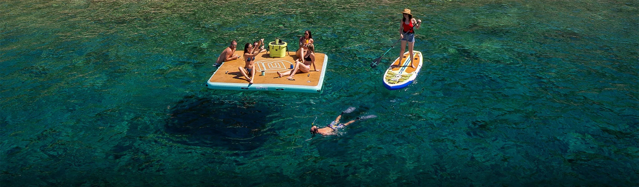 People hanging out on a Hangout Dock while another person is standing on a paddle board