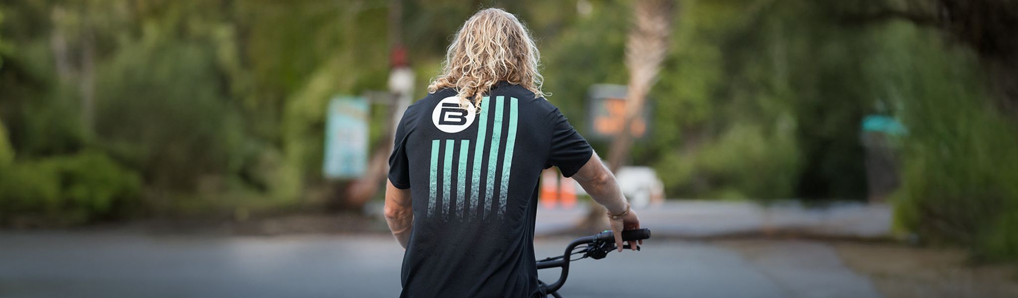 Guy wearing a BOTE Nation T-shirt riding a bike