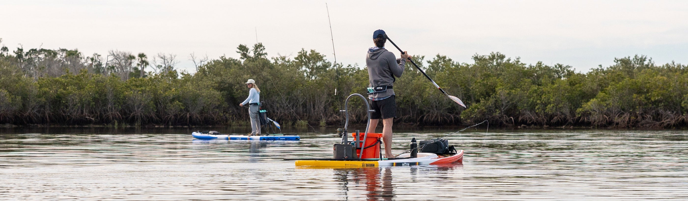 Two people on paddle boards on the water.