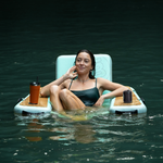 Lifestyle image of a girl sitting in the Inflatable Hangout Chair Classic in the water