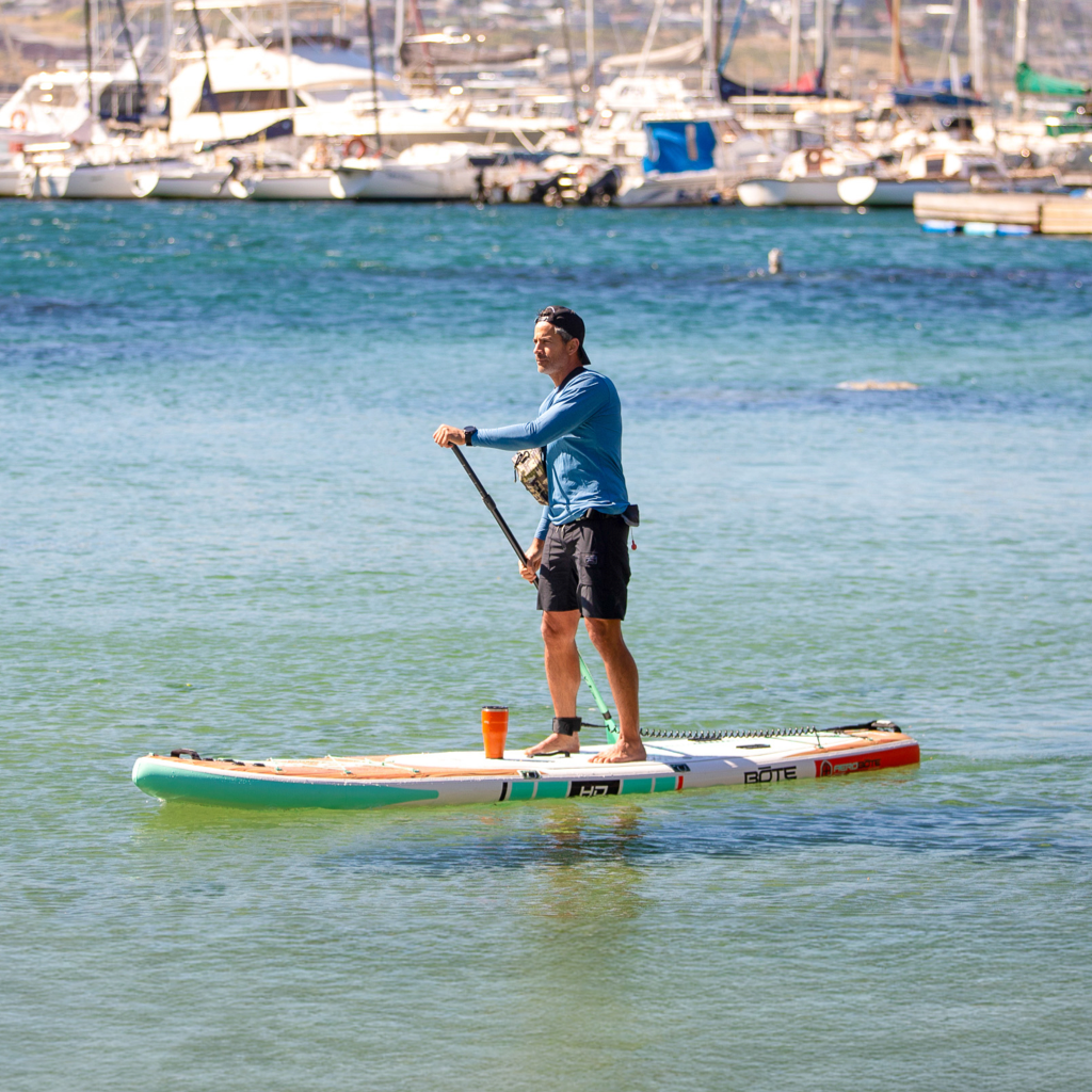 Lifestyle view of a guy paddling on the HD Aero 11′6″ Classic Mangrove Inflatable Paddle Board
