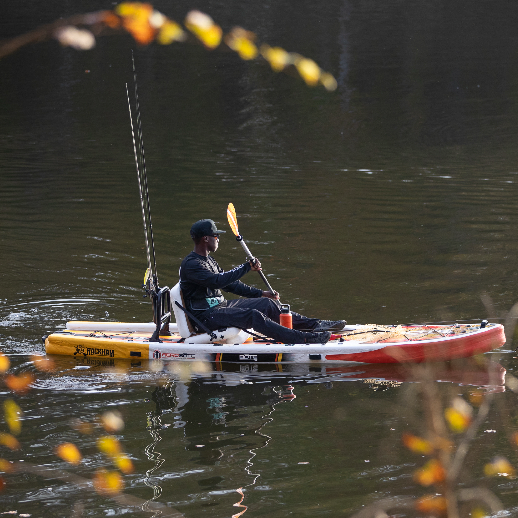 A person sitting on a Rackham Aero 12′4″ Fischer Cutthroat Apex Inflatable Paddle Board paddling on the water
