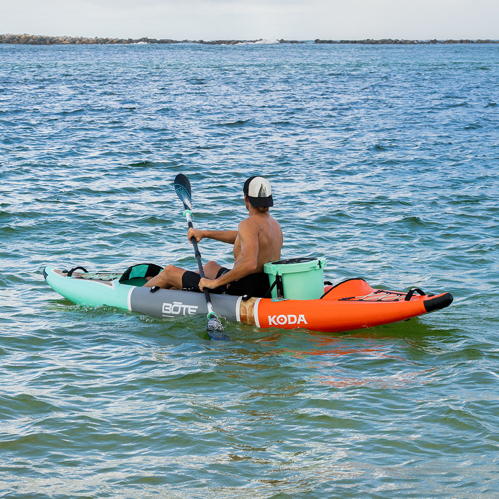 Paddler using the Koda Aero on open water with a mounted cooler behind the seat.
