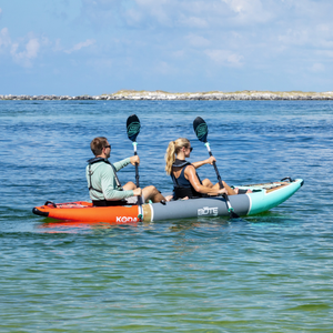Koda Aero Tandem on water with two paddlers cruising across calm ocean.
