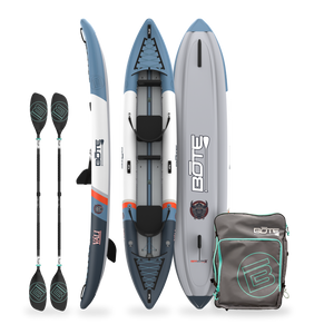 Inflatable kayak with paddles and a carrying bag on a white background