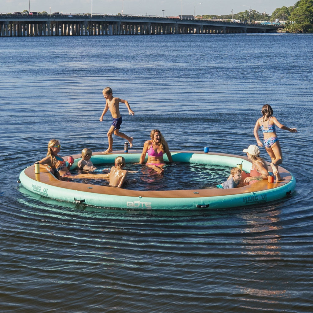 A family lounging and playing on the Inflatable Hangout Water Hammock 15 Classic