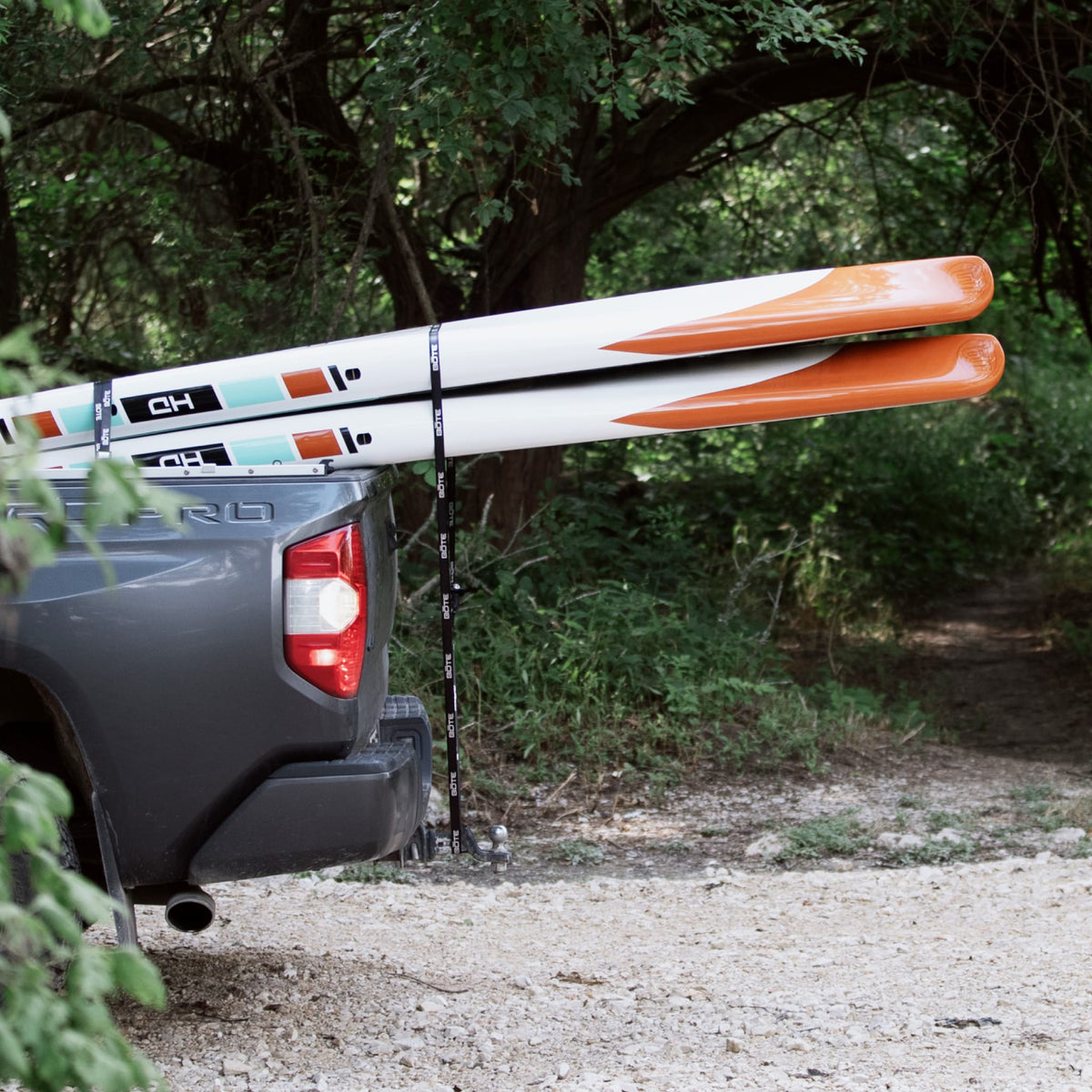 Two paddle boards strapped in a pickup truck bed using Cam Straps.