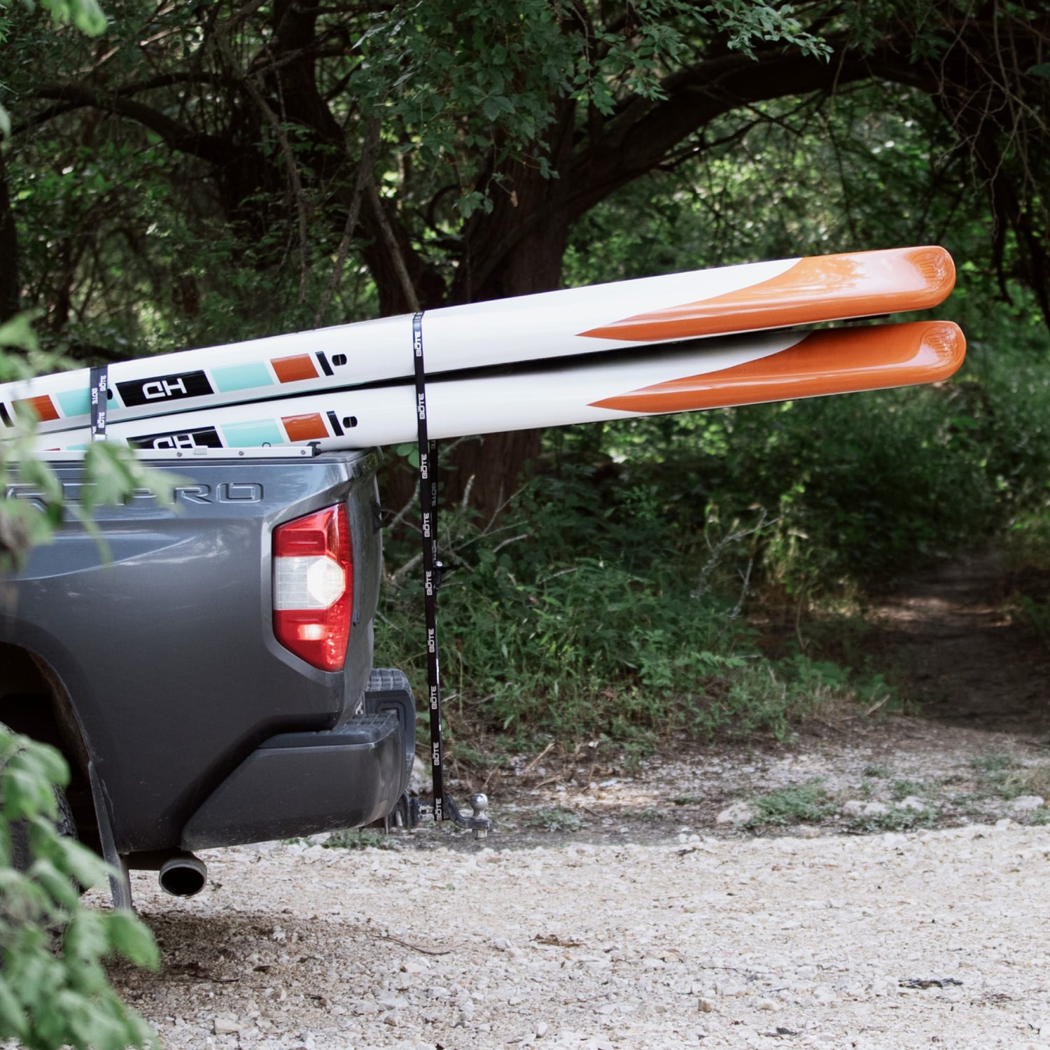 View of the BOTE Cam Straps holding two paddle boards in the back of a truck.