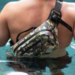 Person wearing Highwater Belt Pack Verge Camo across shoulder while wading in water.