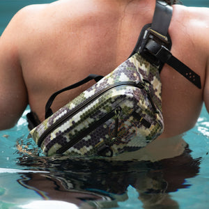 Person wearing Highwater Belt Pack Verge Camo across shoulder while wading in water.