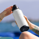 A person handing a MAGNEBottle 36oz with Cap White to someone