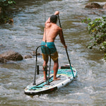 Lifestyle image of Tackle Rac Black on paddle board as man paddles through a river.