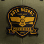 Closeup on the patch of Eagle Supply Trucker Hat in Green with black and yellow logo with eagle holding a paddle.