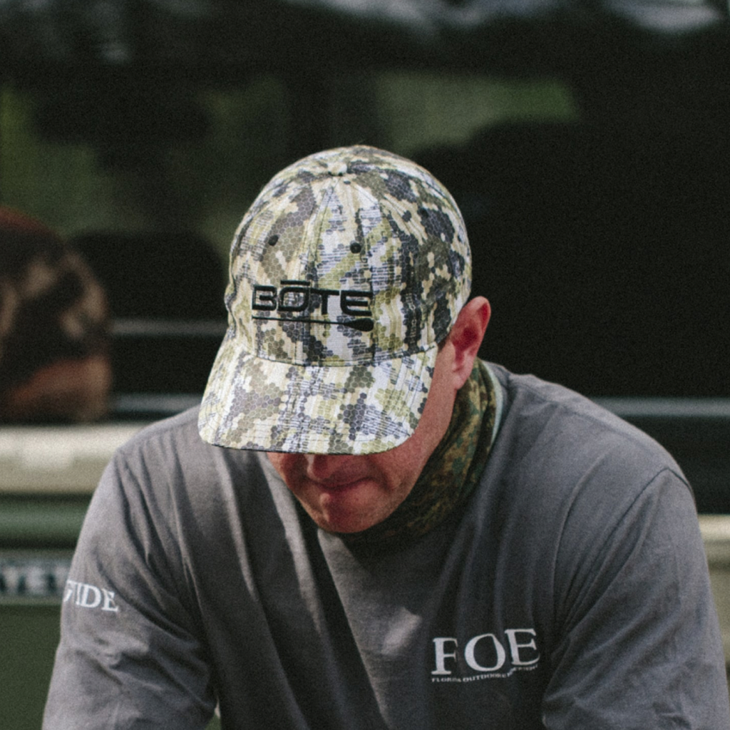 An image featuring a person wearing the BOTE Logo Verge Camo Ripstop Hat with Camo Print and Black BOTE Logo.