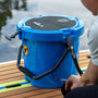Picture of someone tying down the KULA 5 MAGNEPOD™ Cooler Harbor Blue to a paddle board