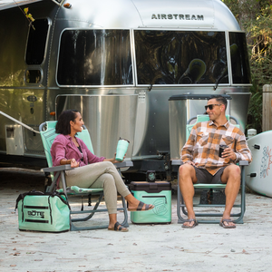 Mule Series Full Haul set with chairs, cooler and gear beside camper trailer outdoors.