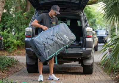 Carry bag for the Koda Aero being loaded into the back of an SUV for transport.