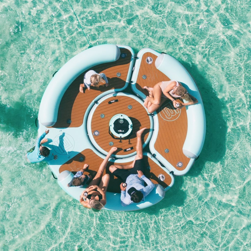 Overhead view of people lounging on the Inflatable Dock Hangout 360 Duo with Bar in the water