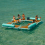 People lounging on the Inflatable Dock Hangout Quad Square [Port] on the water