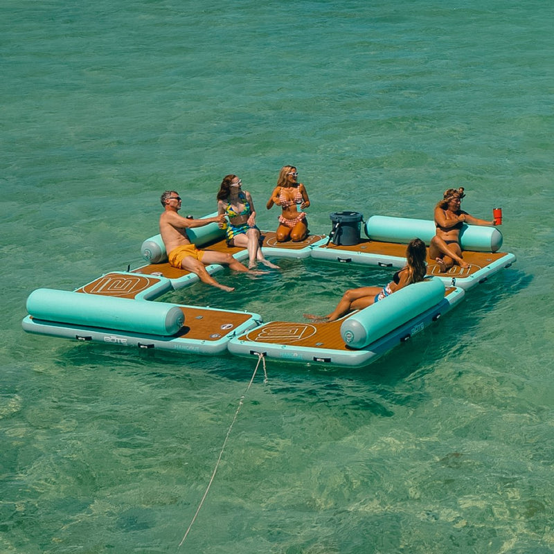 People lounging on the Inflatable Dock Hangout Quad Square [Port] on the water