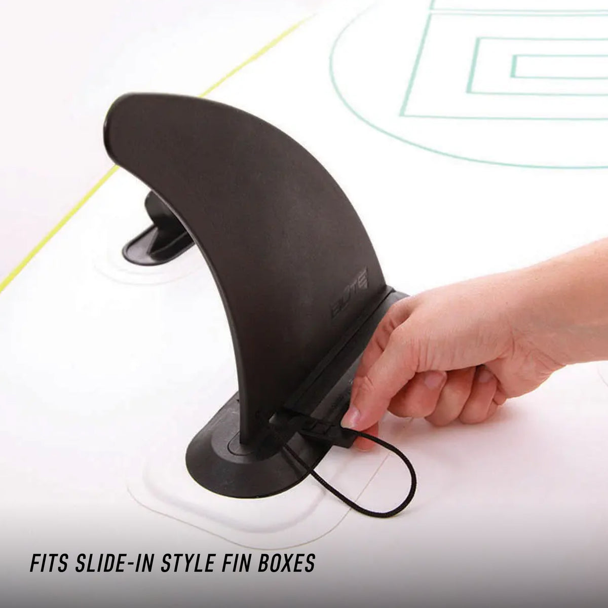 Close-up of hand installing a black center fin into a slide-in style fin box on a SUP.