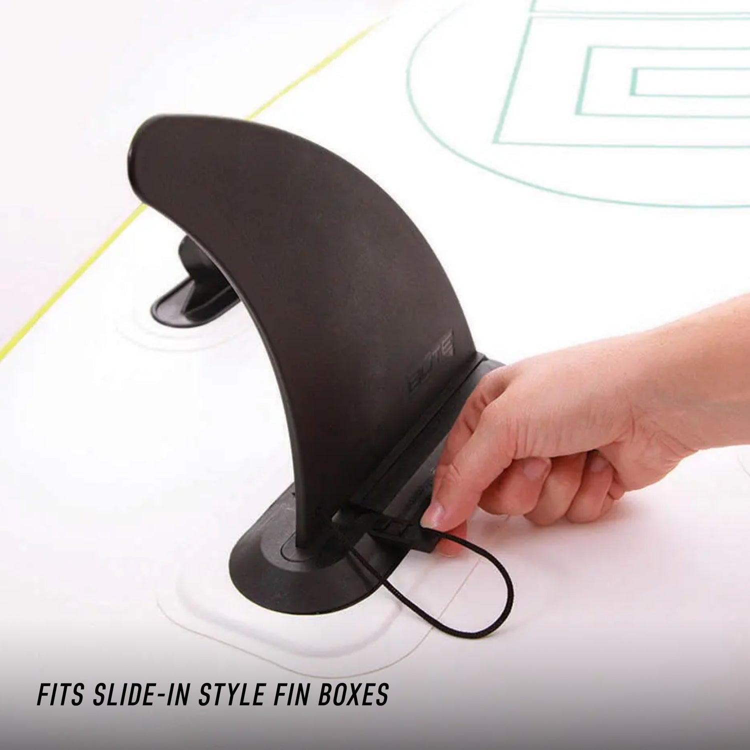 Close-up of hand installing a black center fin into a slide-in style fin box on a SUP.