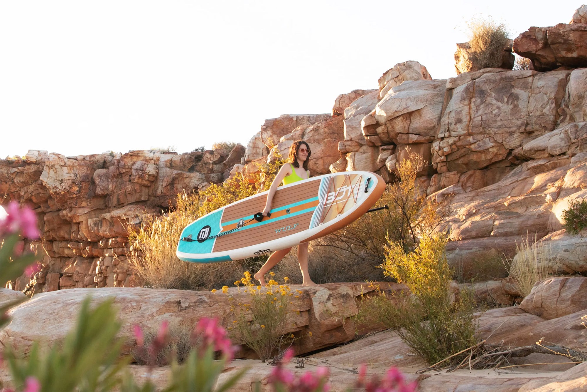 Woman carrying the WULF Aero with flowers and rocks in the background.