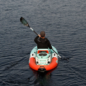Person paddling a small inflatable kayak on calm water