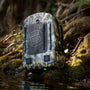 Verge Camo Highwater Backpack sitting at the edge of some water in 