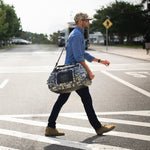 Man carrying Verge Camo Highwater Duffel over his shoulder as he walks across the street