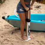 Woman using the white Aero hand pump to pump up her DEUS Aero inflatable kayak