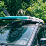 Paddle board on top of a SUV with roof racks and roof rack pads