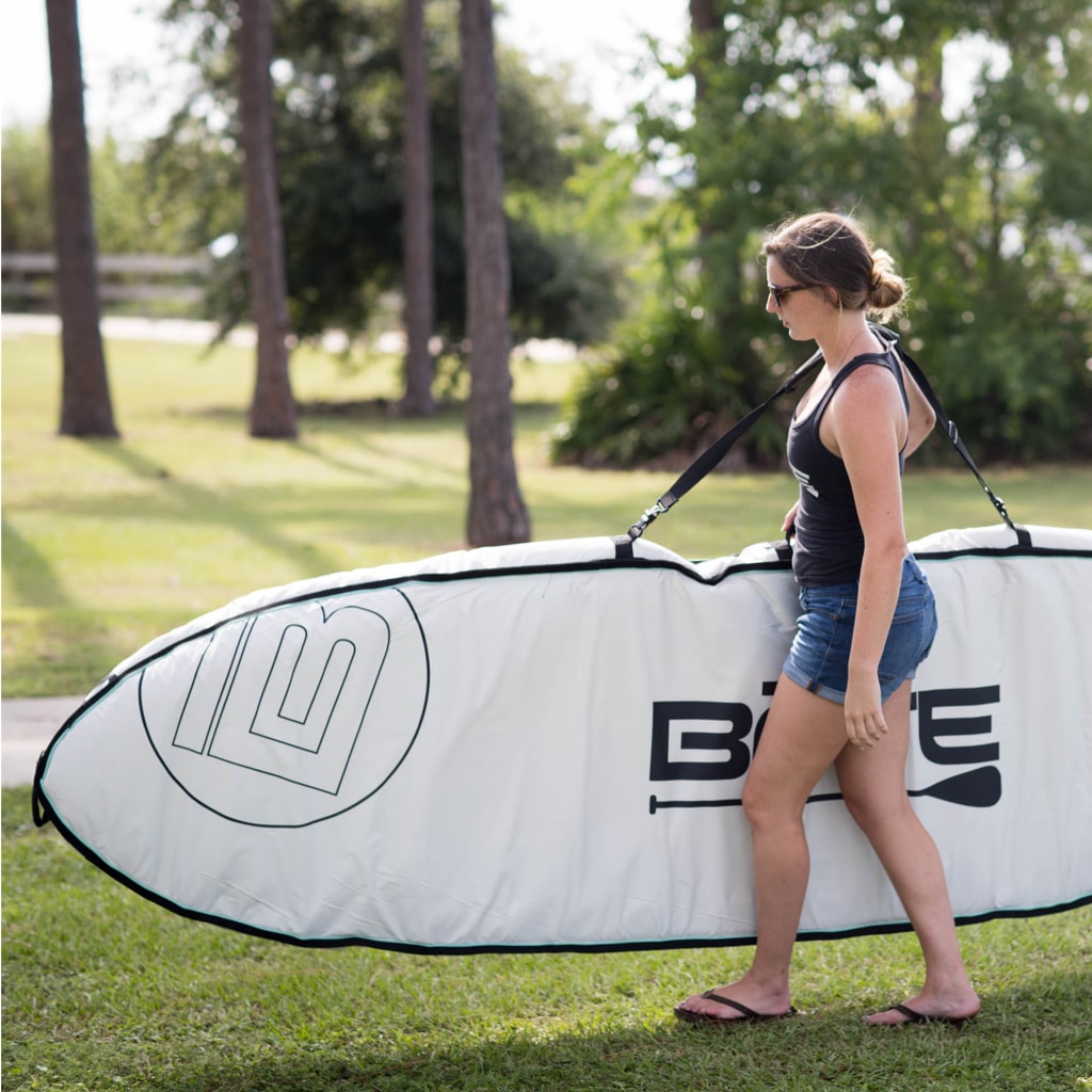 woman carrying her paddle board in a board bag