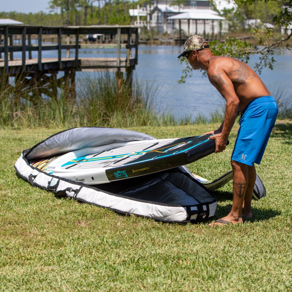 Man putting his Rackham Paddle Board into a board bag