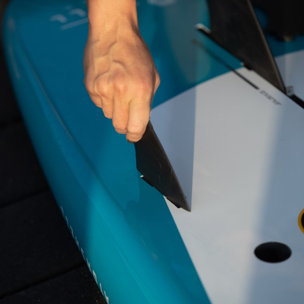 Woman installing a side bite fin into her HD paddle board
